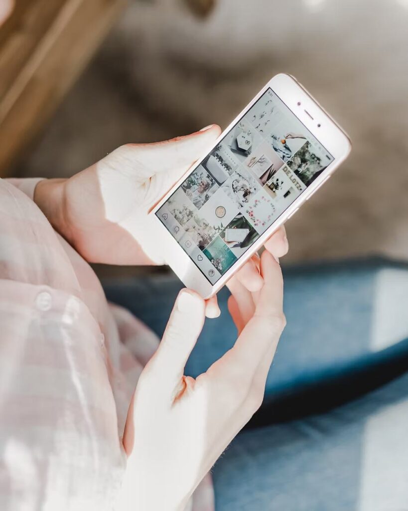 Person holding a smartphone viewing a curated Instagram feed.