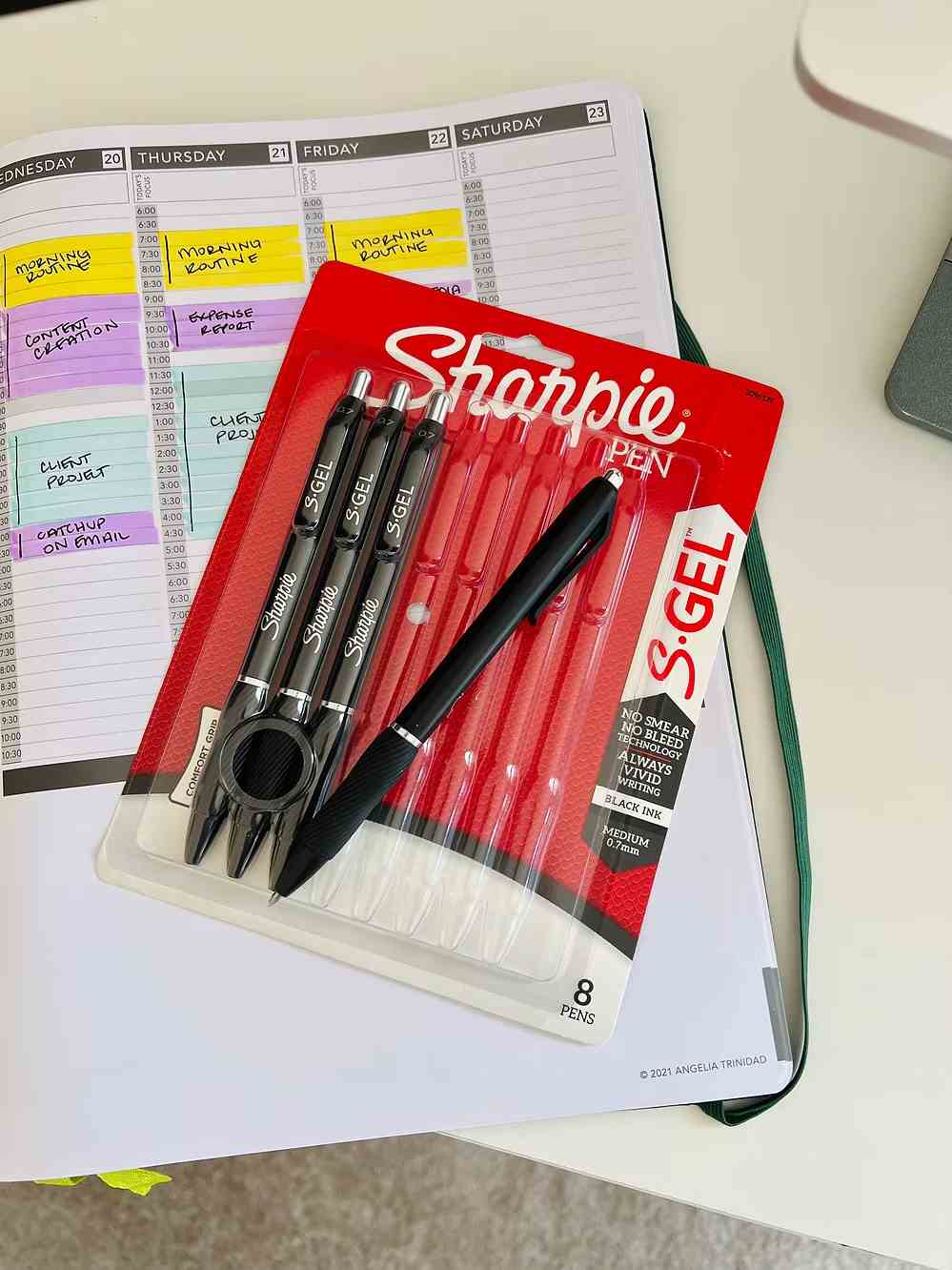 Pack of Sharpie S-Gel pens on a planner with handwritten schedule highlighting productivity tasks.