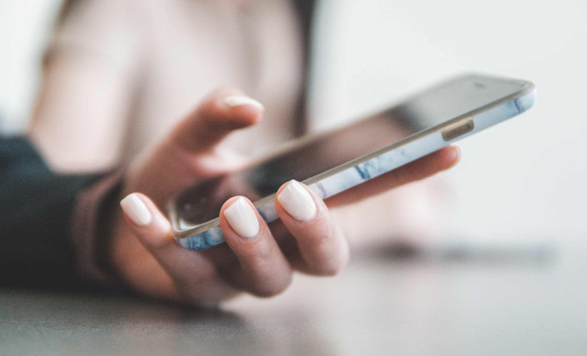 Hand holding smartphone with marble case