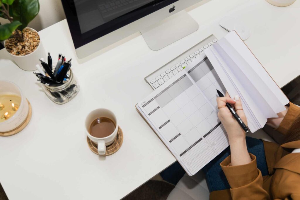 Workspace with iMac, planner, and coffee