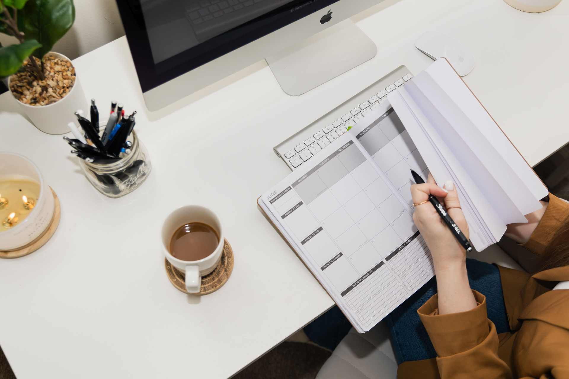 Workspace with iMac, planner, and coffee
