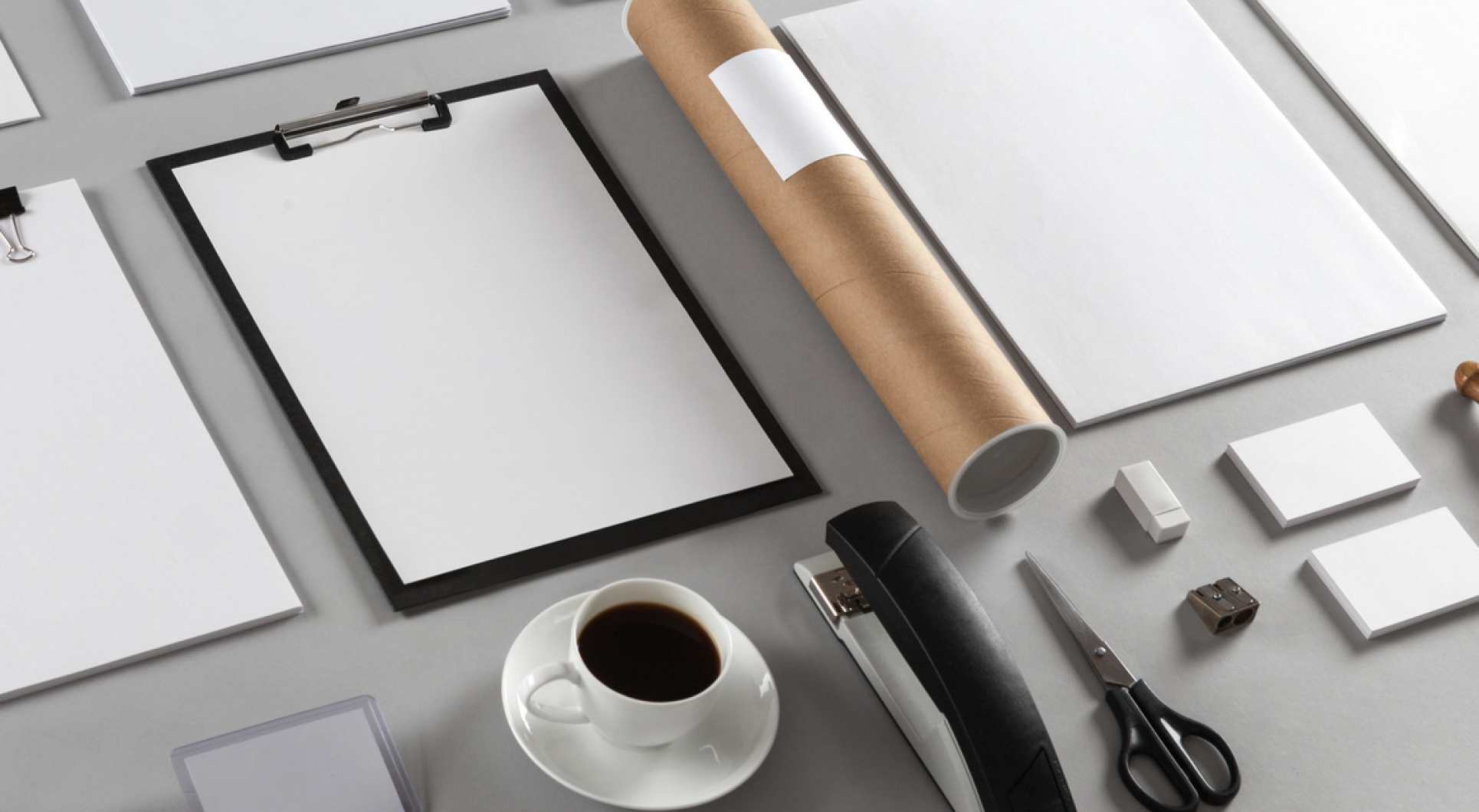 Flat lay of office supplies with coffee, notepad, scissors, and other desk essentials.