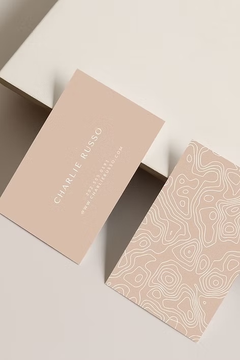 Minimalist pink business cards with organic topographic pattern design and clean typography.