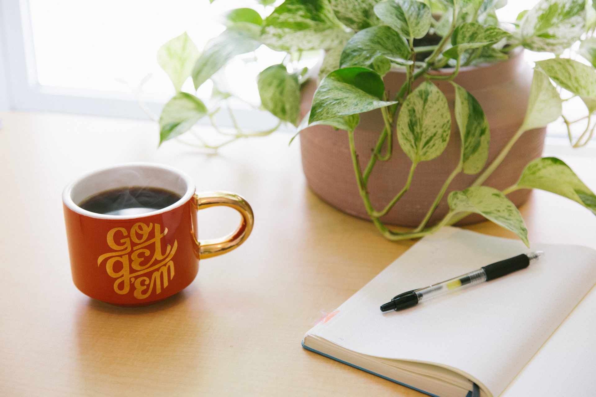 Coffee mug with motivational text and notebook