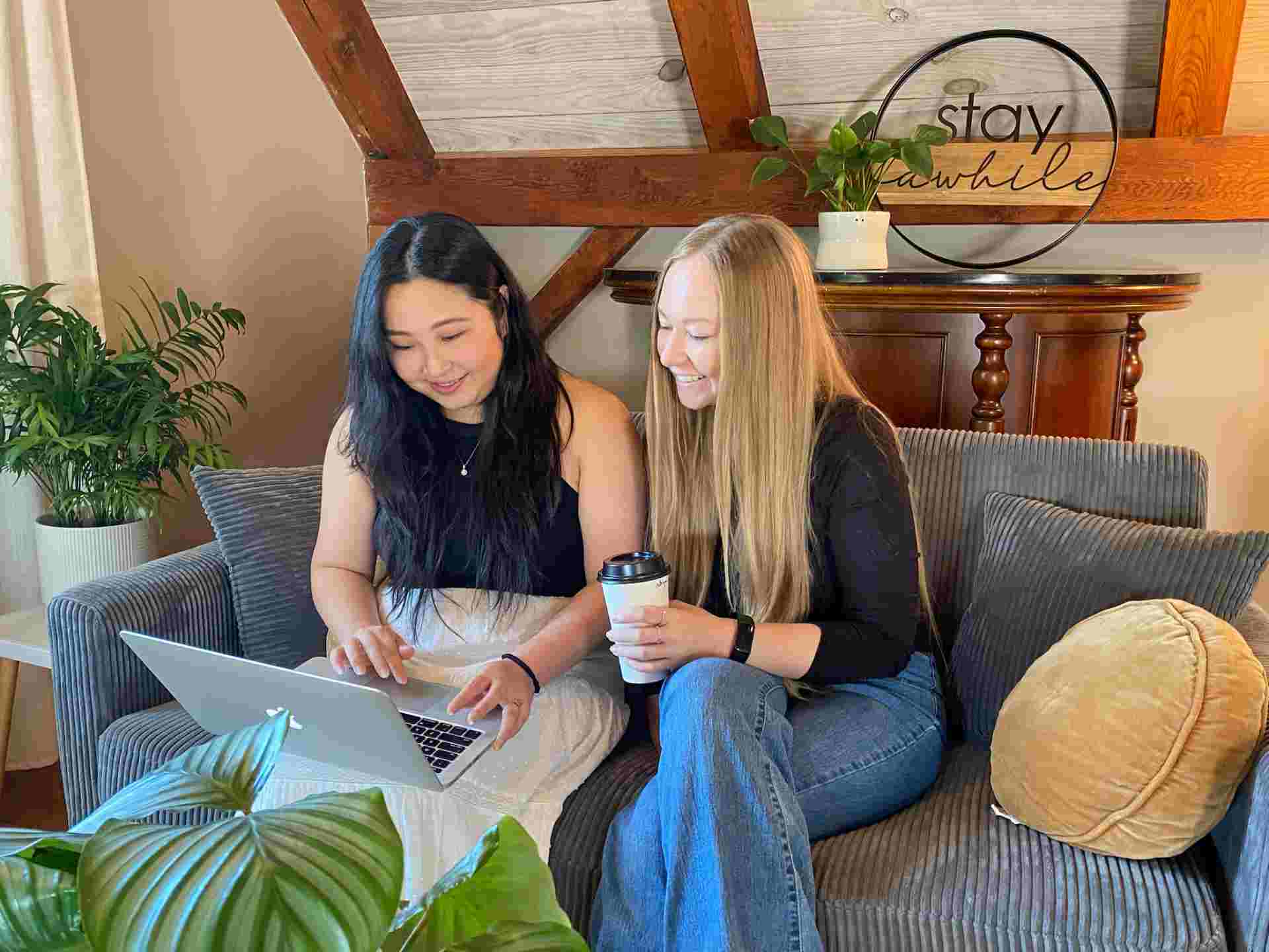 Two people collaborating on laptop in cozy room