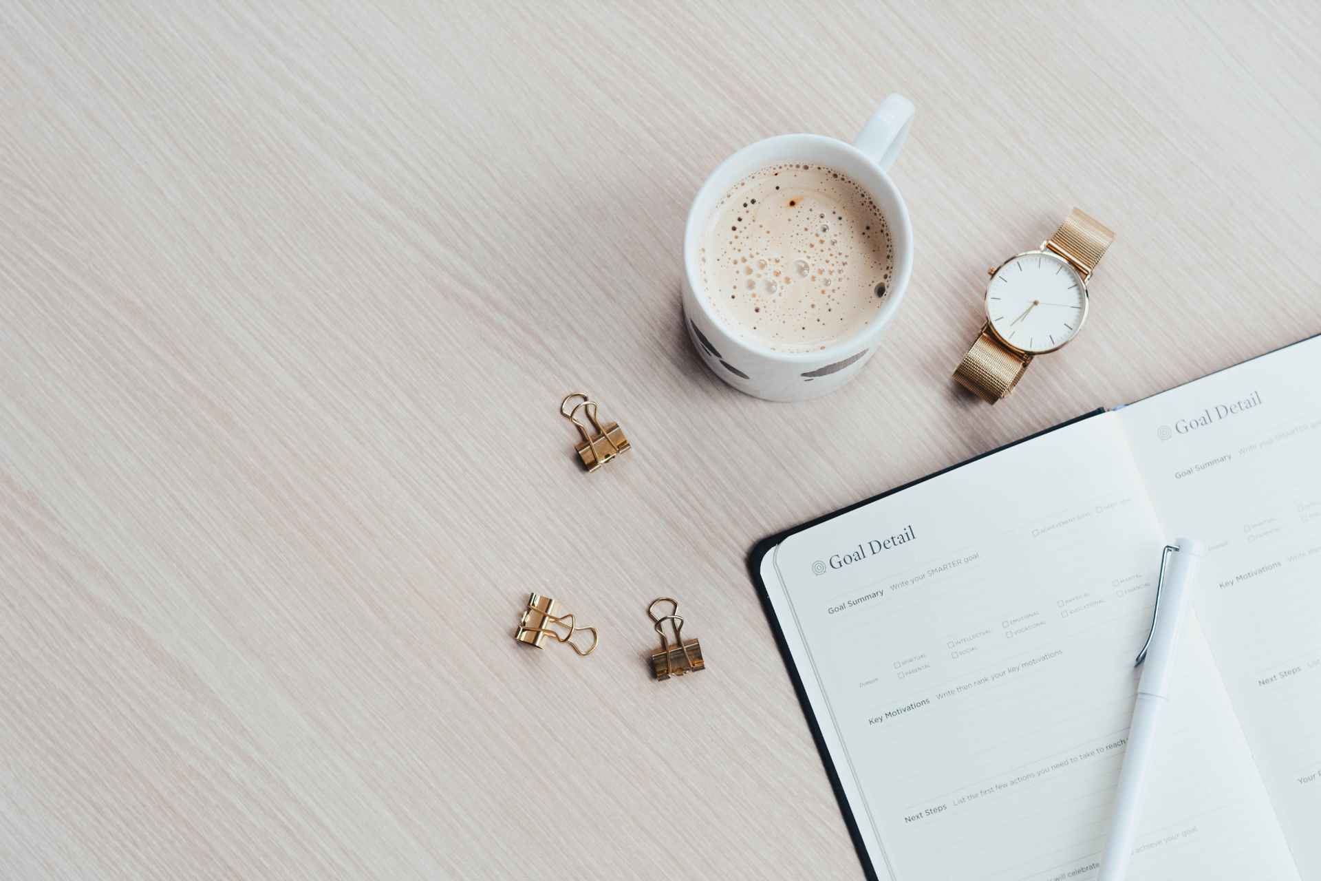 Workspace with coffee, notebook, and goal planning template